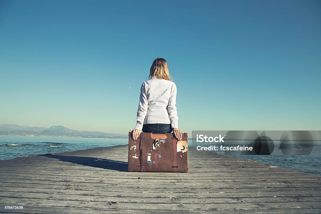 Frau sitzt auf Ihre Koffer warten auf den Sonnenuntergang - Lizenzfrei Frauen Stock-Foto