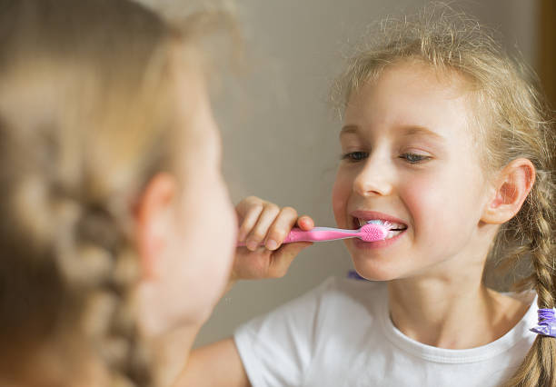 istock Little girl brushing her teeth with toothbrush. 515674460
