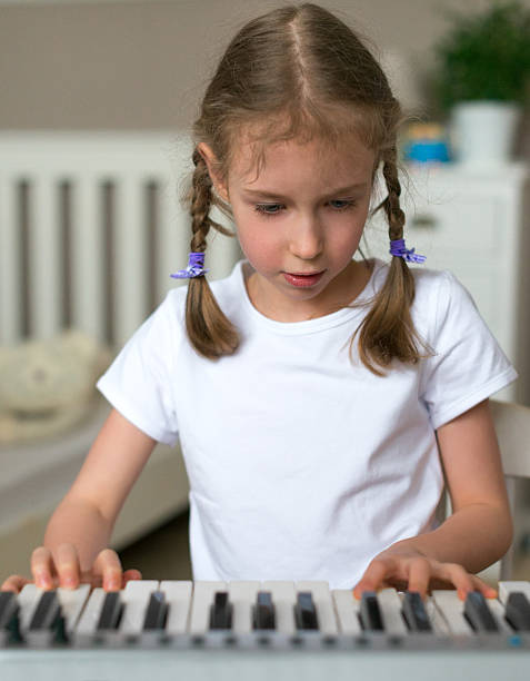 istock Cute little girl learning to play the piano. 515674502