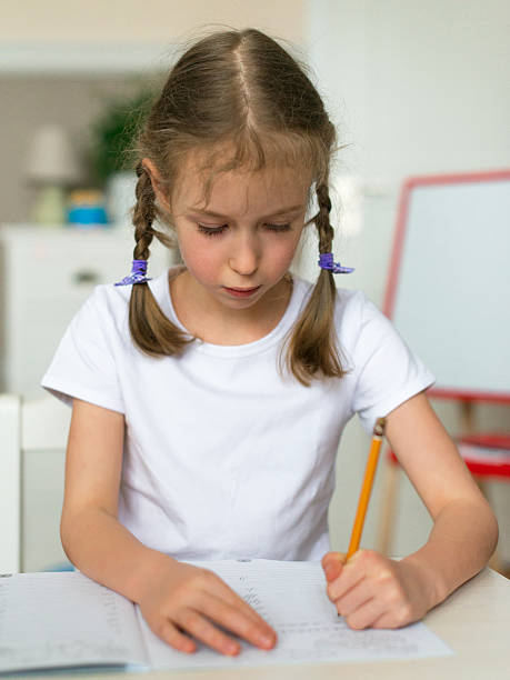 istock Cute little girl doing her homework for school. 515674666