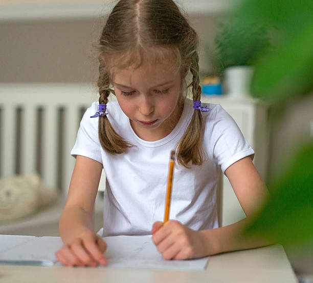 istock Cute little girl doing her homework for school. 515674726