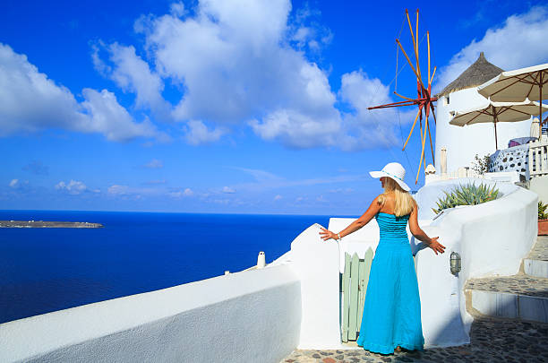 istock Blond woman in front of windmill at Santorini 515675148