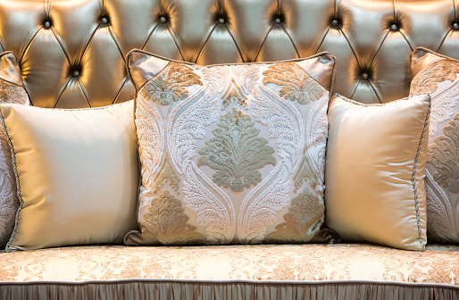 Luxury and classic style pillows on a shiny leather sofa.