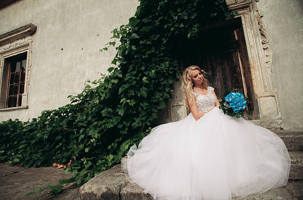 istock Beautiful young blond bride with bridal bouquet sitting on the 515676070