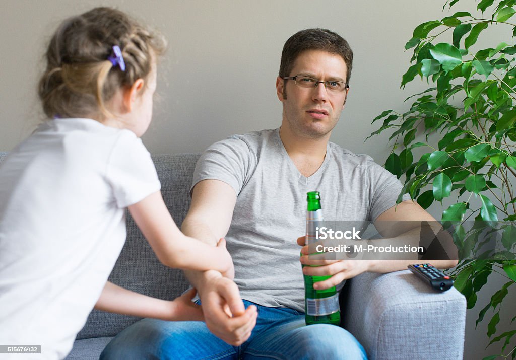 Little girl calling dad to play while he watching TV. Adversity Stock Photo