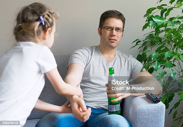 Little Girl Calling Dad To Play While He Watching Tv Stock Photo - Download Image Now