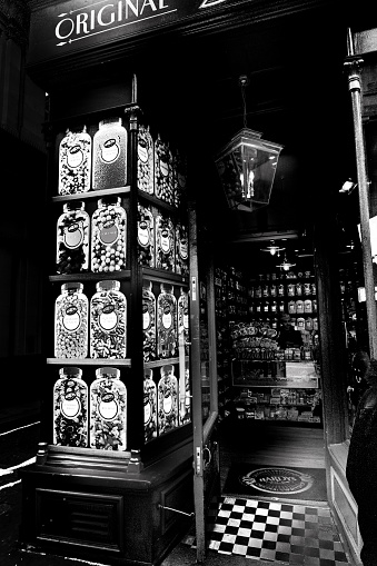 London, UK - February 27, 2016: Old fashioned sweet shop façade on London street. Shopkeeper is pictured inside
