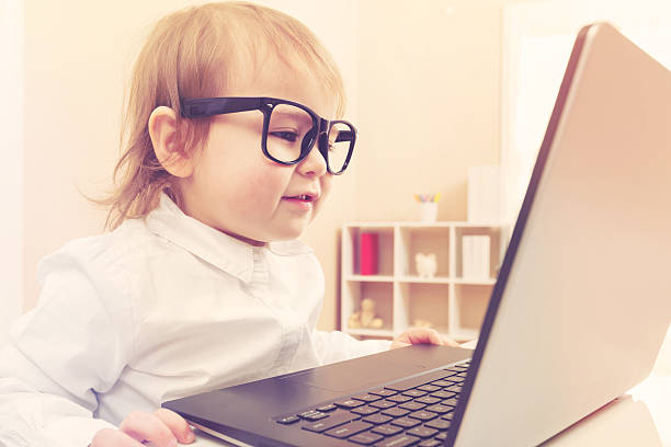 istock Smart toddler girl wearing big glasses using her laptop 515679238