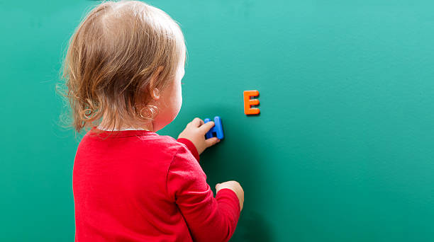 istock Toddler girl learning her letters on a chalkboard 515679566