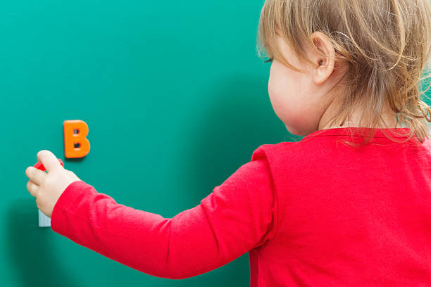 istock Toddler girl learning her ABCs on a chalkboard 515679608