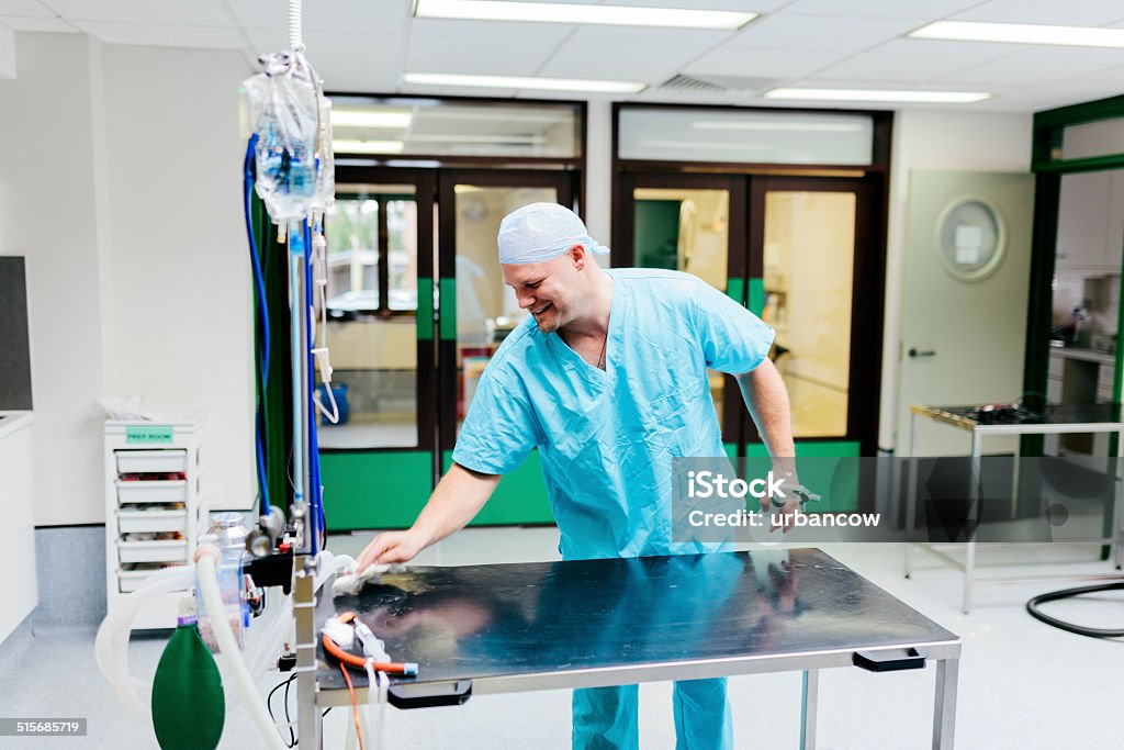 Veterinary Surgeon cleaning equipment A Veterinary Surgeon cleaning a table in a Veterinary Hospital Cleaning Stock Photo