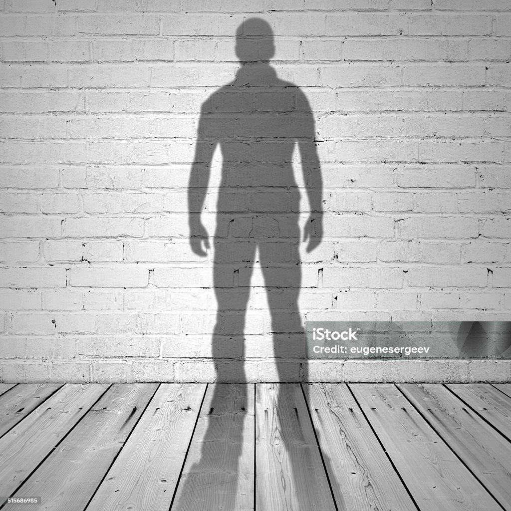 Shadow of a man on white brick wall Shadow of a man on white brick wall and wooden floor Shadow Stock Photo