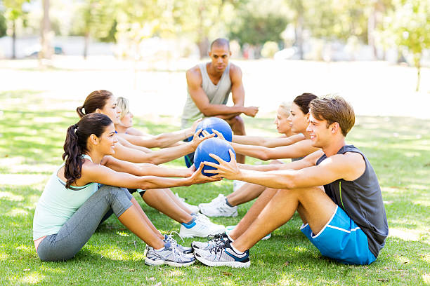 istock Fitness Instructor Motivating People Exercising With Medicine Ball 515689473