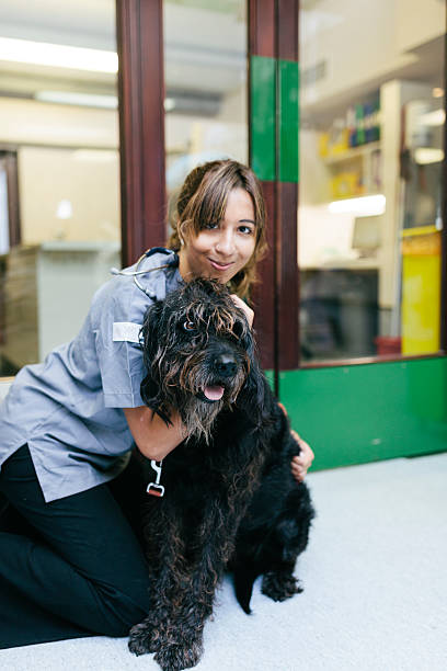 weterynaryjne pielęgniarka z pies - portrait animal hospital embracing holding zdjęcia i obrazy z banku zdjęć