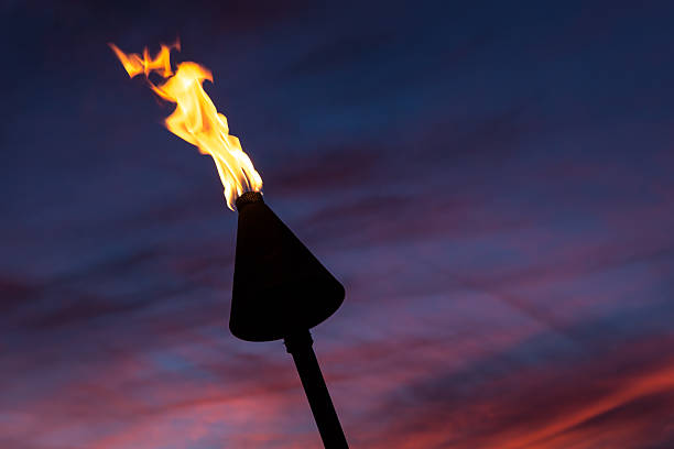 istock Tiki Torch Flames on Tropical Beach at Sunset, Kauai, Hawaii 515701589