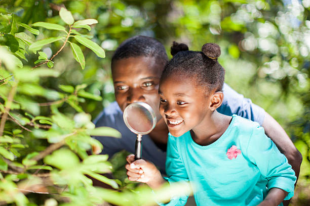 istock African father and daughter using a magnifying glass 515701829