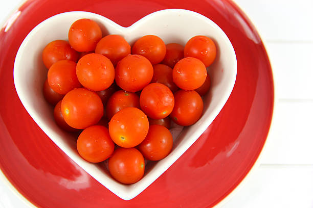 istock Cherry tomatoes in a heart shaped bowl on red plate 515702845