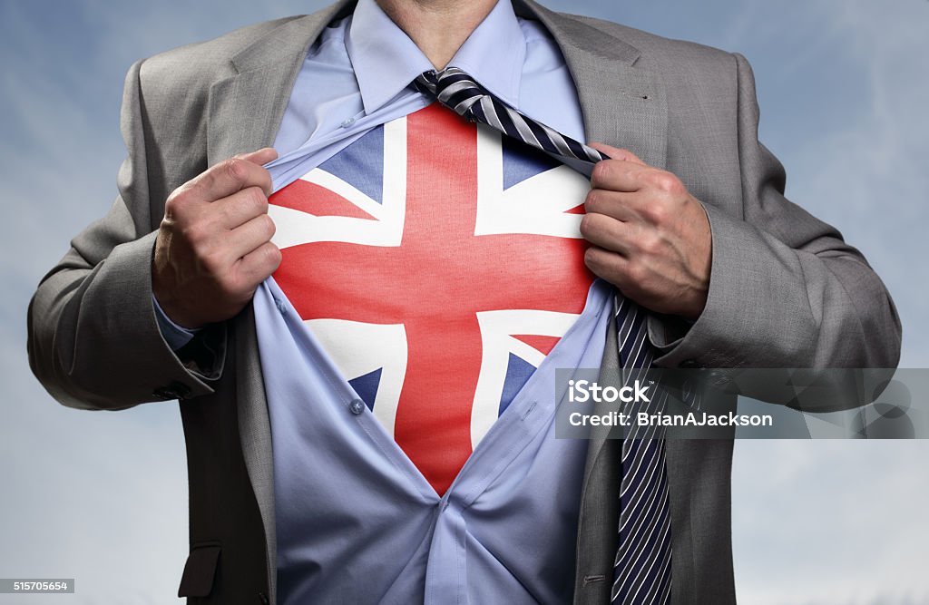 Superhero businessman revealing British flag Businessman in classic superman pose tearing his shirt open to reveal t shirt with the British union jack flag concept for european referendum, patriotism, freedom and national pride England Stock Photo