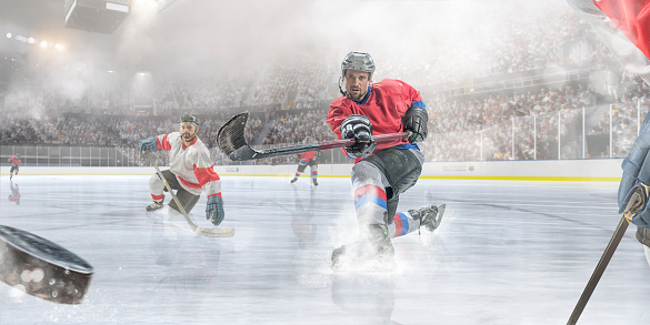 Professional ice hockey player sliding on ice with one knee and having just hit puck during ice hockey game. Action takes place in a cold, misty indoor ice hockey arena full of spectators. All players are wearing generic icy hockey kit and using unbranded sticks.  With intentional water spray effects. 