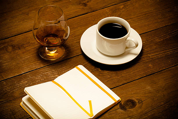 istock White cup of coffee, cognac in a glass and notebook 515707720