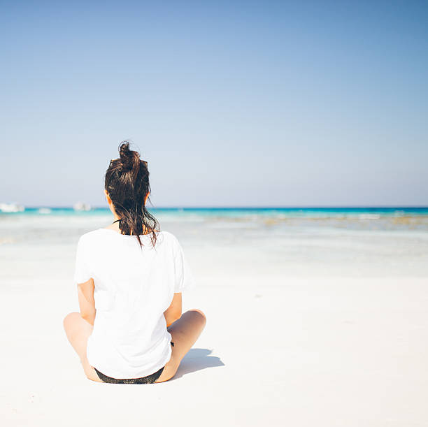 Young Asian girl sitting on the tropical beach paradise of ko tachai island, Similan National Park, Thailand.