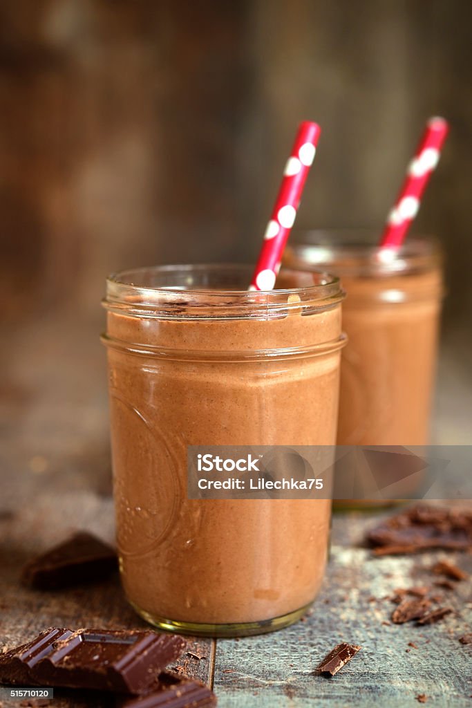 Chocolate banana smoothie. Chocolate banana smoothie on a rustic wooden background. Smoothie Stock Photo