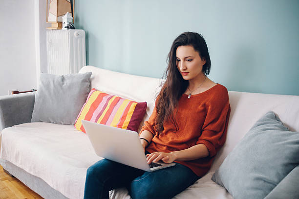 istock Young woman relaxing at home with a laptop 515710884