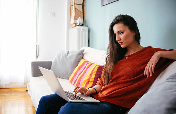 istock Young woman relaxing at home with a laptop 515711178