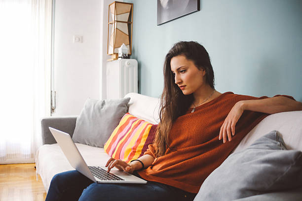 istock Young woman relaxing at home with a laptop 515711280
