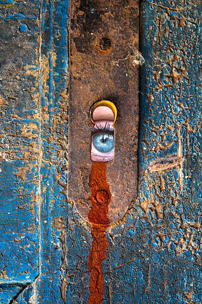 Women eye staring through the keyhole Women eye staring through the old keyhole woman spying through a keyhole stock pictures, royalty-free photos & images