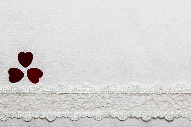 istock Lace ribbon hearts on white cloth. 515715274