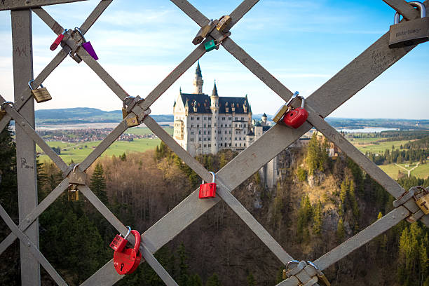 Hohenschwangau, Germany - April 2, 2014: Love Padlocks hanging on the fence of Marienbrücke with Neuschwanstein Castle behind
