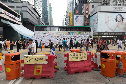 Hong Kong, Hong Kong SAR - September 30, 2014: Pedestrians at Nathan Road in Mong Kok, Hong Kong. A street blocked by barricades and rubbish bins set up by protesters. Occupy Central is a civil disobedience movement which began in Hong Kong on September 28, 2014.