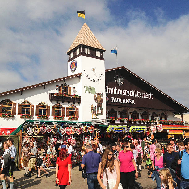 Munich, Germany - September 27, 2014: People walking in front of the Paulaner pub at the Munich Oktoberfest festival. The Oktoberfest is the largest fair in the world about beer and is held annually in Munich at the end of September.