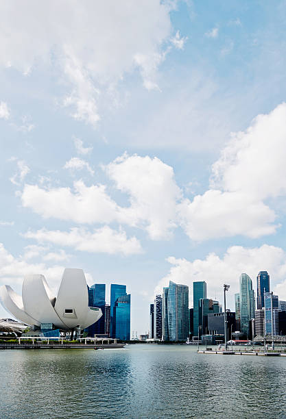 Singapore city, Singapore - January 9, 2016: The ArtScience Museum at Marina Bay Sands, and CBD skyline, Singapore. ArtScience Museum is in the shape of a lotus flower opening. It become a famous tourist attractions in Singapore. Tourists are sightseeing at the waterfront area.