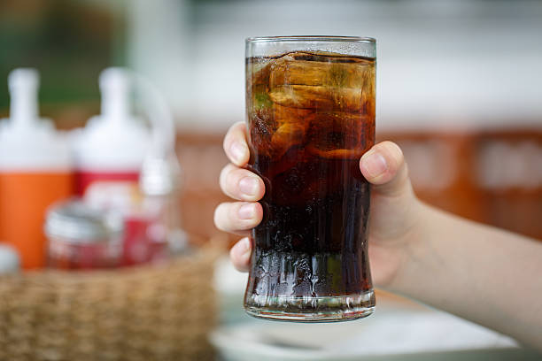 istock Hand holding glass of cola drink 515741154