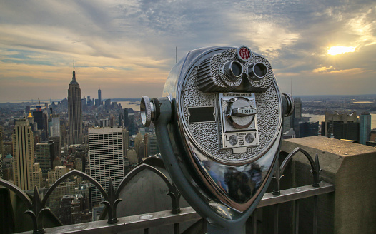 Coin operated binoculars and Empire State Building at sunset.