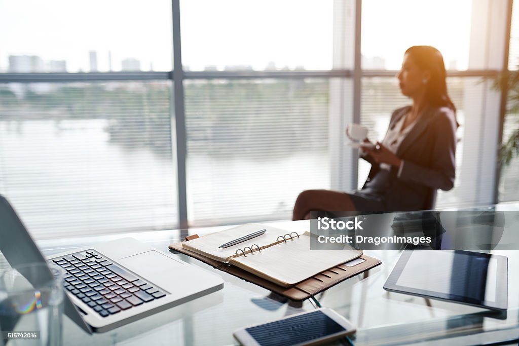 Workplace of business executive Table of business lady who is drinking tea in the background Occupation Stock Photo