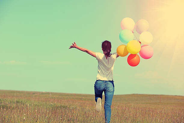 istock young asian woman  with colored balloons 515743559