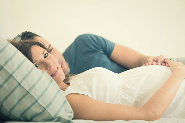 istock Happy expecting pregnant couple laying down on bed 515745963