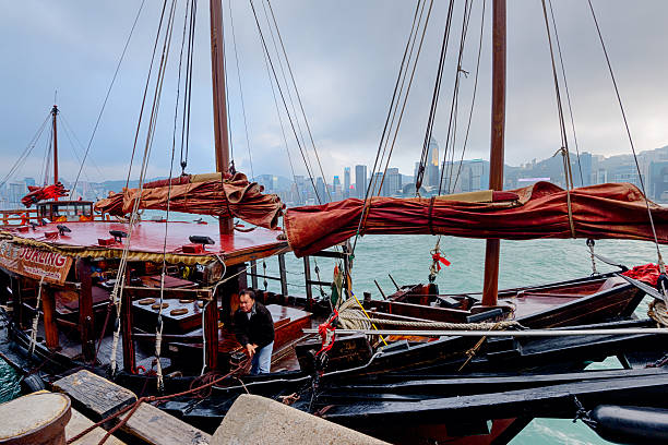Hong Kong, China - January 31, 2016: A Traditional Chinese Junk boat is about to dock at Victoria Harbor in Hong Kong. 