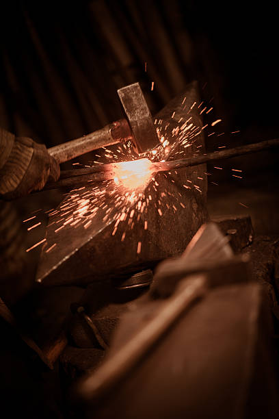 istock Blacksmith shaping a hot piece of iron-anvil with a hammer 515750968