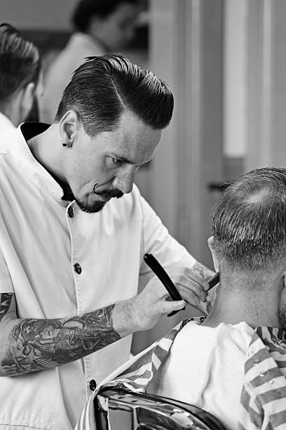 istock moustached barber razor shaving back of customers head 515768691