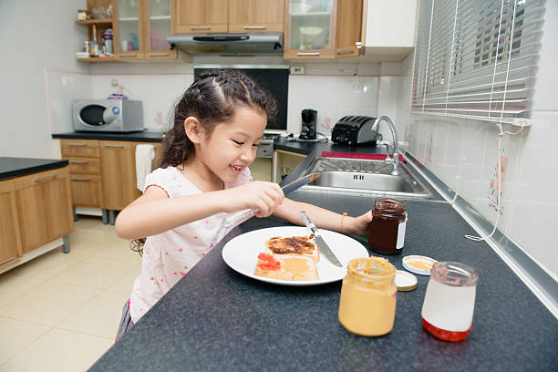 istock Thai Girl Making a Peanut Butter Jelly Sandwich 515770867