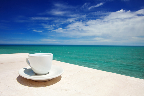 A cup of coffee with Mediterranean sea at the background
