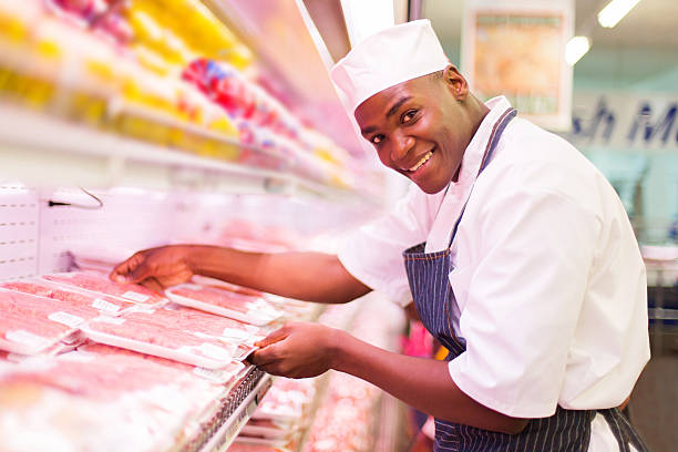 african butcher working in butchery happy african butcher working in butchery refrigerated section supermarket photos stock pictures, royalty-free photos & images
