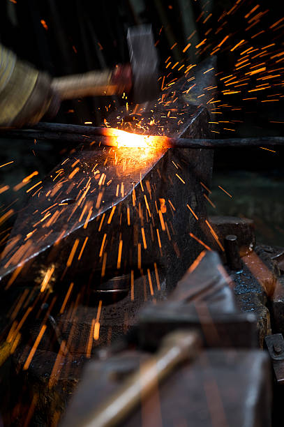 istock Blacksmith shaping a hot piece of iron-anvil with a hammer 515777994
