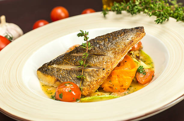 istock Grilled dorado fish with fried potatoes, lemon and tomato 515779650
