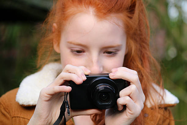 immagine di donna con capelli rossi scattare foto con la fotocamera digitale compatta, bosco - fotocamera compatta foto e immagini stock