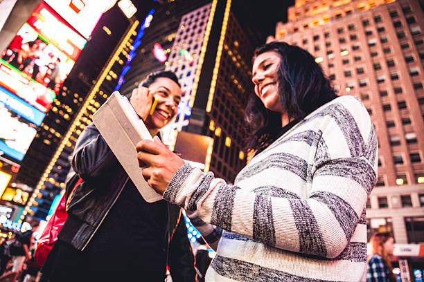 zwei freunde in times square - digital tablet travel destinations new york state times square stock-fotos und bilder